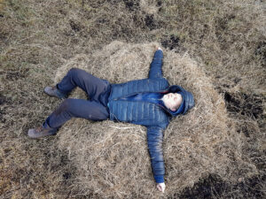 young man laying on the pile of hay femlens